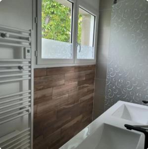 a bathroom with a sink and a window at La petite maison in Pontis