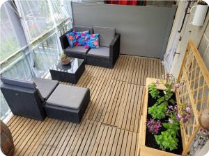 a balcony with a couch and a table and flowers at La petite maison in Pontis