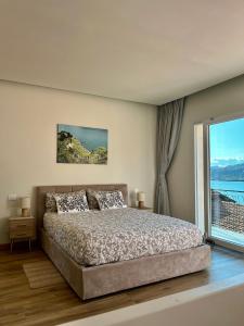 a bedroom with a bed and a large window at Villa Giulietta lake view Jacuzzi Spa 108 in Blevio