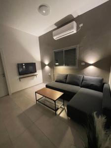 a living room with a couch and a table at בית בעמק בעיצוב מודרני וחמים in Bet Sheʼan