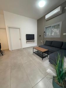 a living room with a couch and a tv at בית בעמק בעיצוב מודרני וחמים in Bet Sheʼan +3 photos