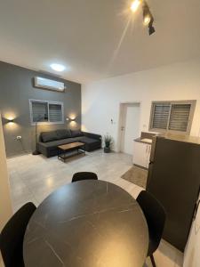 a living room with a table and a couch at בית בעמק בעיצוב מודרני וחמים in Bet Sheʼan