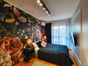 a bedroom with a large painting on the wall at Bronowicka Comfort Apartment in Kraków