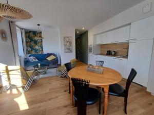 a kitchen and dining room with a table and chairs at Le Richelieu "Côté sud" Appartement 302 in La Bourboule