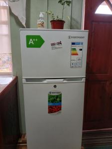a white refrigerator with magnets on the top of it at Nature's Haven in Marigot