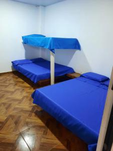 two beds in a room with blue sheets at FINCA CAMPESTRE EL MIRADOR VIOTA in Viotá