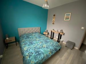 a bedroom with a bed and a blue wall at CHAMBRE D HÔTE CHEZ Nath in Sadirac