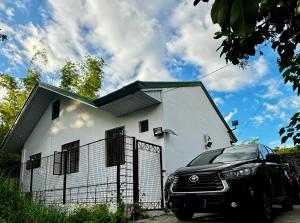 a car parked in front of a white house at Full AC 4BR & LivingRm entire vacation home at Vigan City in Vigan