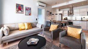 een woonkamer met een bank, stoelen en een tafel bij Vuokatti Weekend Piste in Vuokatti