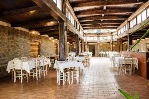 una sala da pranzo con tavoli e sedie bianchi di Residence Le Corniole ad Arezzo