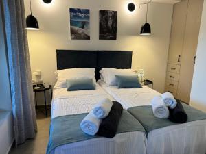 a bedroom with two beds with towels on them at South Palms luxury village house in Áno Rodhákinon