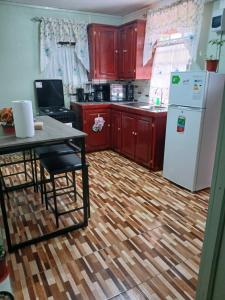 a kitchen with red cabinets and a white refrigerator at Nature's Haven in Marigot