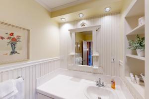 ein weißes Badezimmer mit Waschbecken und Spiegel in der Unterkunft Seventh Street Cottage in Gearhart + 33 Fotos