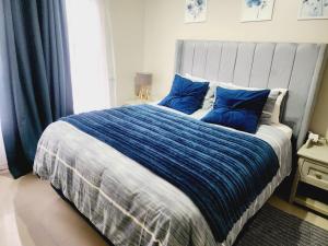 a bedroom with a large bed with blue pillows at Lemon tree in Pretoria
