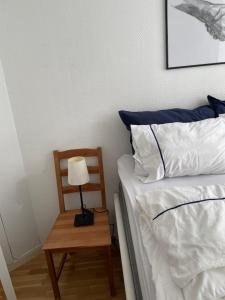 Una cama con una lámpara y una silla al lado. en Vindmølle, en Stavanger 10 fotos más