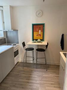 una cocina con 2 sillas y una mesa con una pintura en Vindmølle, en Stavanger