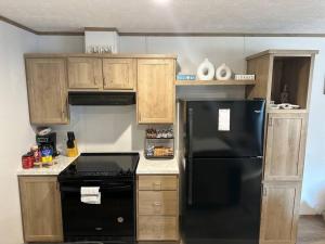 a kitchen with a black refrigerator and wooden cabinets at Ferry Retreat in Cedar Island