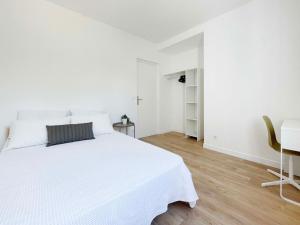 a white bedroom with a white bed and a desk at Ma Belle Conciergerie - Le Cocon Mélunais in Melun