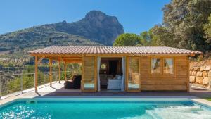 un chalet en bois avec piscine face à une montagne dans l'établissement Miralvalle El Gastor by Ruralidays, à El Gastor