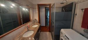 Un baño con dos lavabos y un espejo grande. en Pellico Apartment, en Brusaporto 15 fotos más