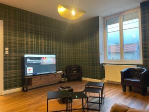 a living room with a flat screen tv and chairs at Les Croisés&Spa in Azannes-et-Soumazannes