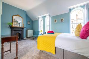 a bedroom with a bed with a yellow blanket on it at Boutique Homes At 4 in Bangor