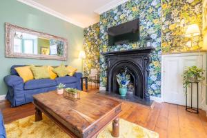 a living room with a blue couch and a fireplace at Boutique Homes At 4 in Bangor