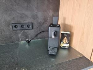 a phone sitting on a glass table next to a box at Gemütliche Ferienwohnung mit 1 Schlafzimmer, Wohnzimmer mit Schlafcouch & voll ausgestattete Küche in Rauschenberg