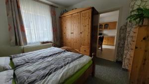 a bedroom with a bed and a wooden cabinet at Oleander in Güntersberge