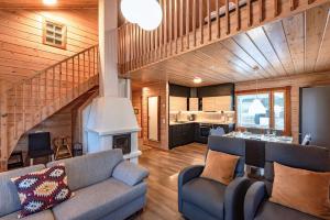 a living room with a couch and a staircase at Vuokatti Weekend Grande in Vuokatti