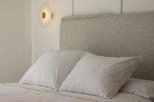 a white bed with a white pillow on it at Soleá Apto en centro de Alhama in Alhama de Granada