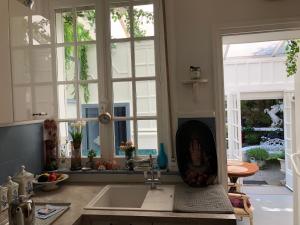 eine Küche mit einem Waschbecken, 2 Fenstern und einem Herd in der Unterkunft Villa EVA Deluxe Bray-dunes Beach in Bray-Dunes + 4 Fotos