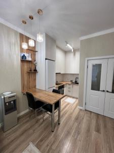 a kitchen with a wooden table and a dining room at Квартира in Taldykolʼ