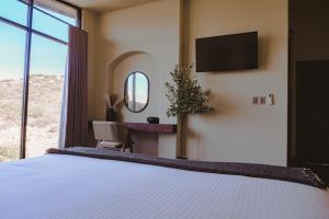 a bedroom with a bed with a tv on the wall at Casa Sekui in Chivato