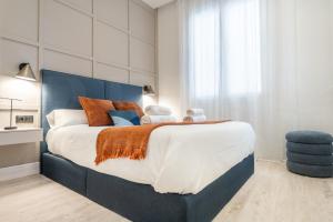 a bedroom with a large bed with a blue headboard at Modern & stylish 3BR in the heart of Malaga by REMS in Málaga