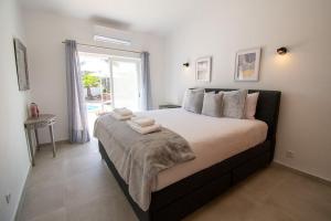 a bedroom with a large bed with towels on it at Pomba beautifully renovated with heated pool! in Poço Partido +44 photos