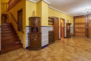 a large room with yellow walls and a staircase at El Capricho del Tejar in Cimanes del Tejar