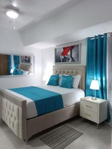 Un dormitorio con una cama grande con cortinas azules. en Boca del Mar III, apartamento 706A, en Boca Chica 45 fotos más