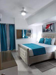 Un dormitorio con una cama grande con almohadas azules. en Boca del Mar III, apartamento 706A, en Boca Chica