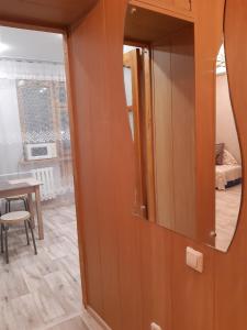 a mirror on a wall in a room with a table at Однокомнатная квартира in Uralsk