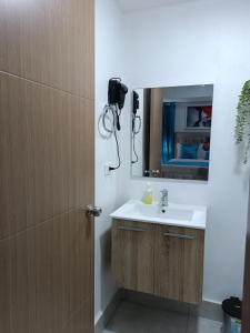 un baño con lavabo y espejo en Boca del Mar III, apartamento 706A, en Boca Chica