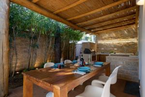 オルビアにあるCasa Il Gelsomino San Pantaleoの木製テーブルと白い椅子付きのキッチン