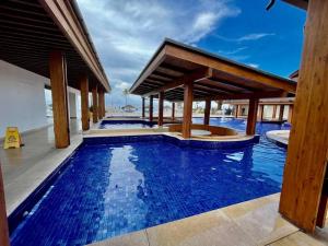 a large swimming pool with a pavilion and a swimming poolvisor at Elegant 5-Bedroom Apartment in Exclusive Playa Escondida Pet Friendly in María Chiquita