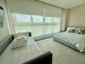 a bedroom with a bed and a couch and a window at Elegant 5-Bedroom Apartment in Exclusive Playa Escondida Pet Friendly in María Chiquita +32 photos