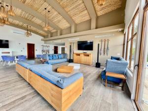 a living room with a couch and blue chairs at Elegant 5-Bedroom Apartment in Exclusive Playa Escondida Pet Friendly in María Chiquita