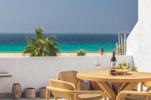 drewniany stół z dwoma kieliszkami wina na plaży w obiekcie Los Lances Beach Apartments w mieście Tarifa