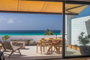 patio ze stołem i krzesłami oraz widokiem na ocean w obiekcie Los Lances Beach Apartments w mieście Tarifa