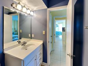 a bathroom with a sink and a mirror at Poolside Paradise in North Topsail Beach