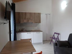 a kitchen with white cabinets and a wooden table at Il giardino di Mary in Càbras