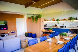 a dining room with a table and blue chairs at Milagres Hospedagens - Praia e Vista Coqueiros in São Miguel dos Milagres